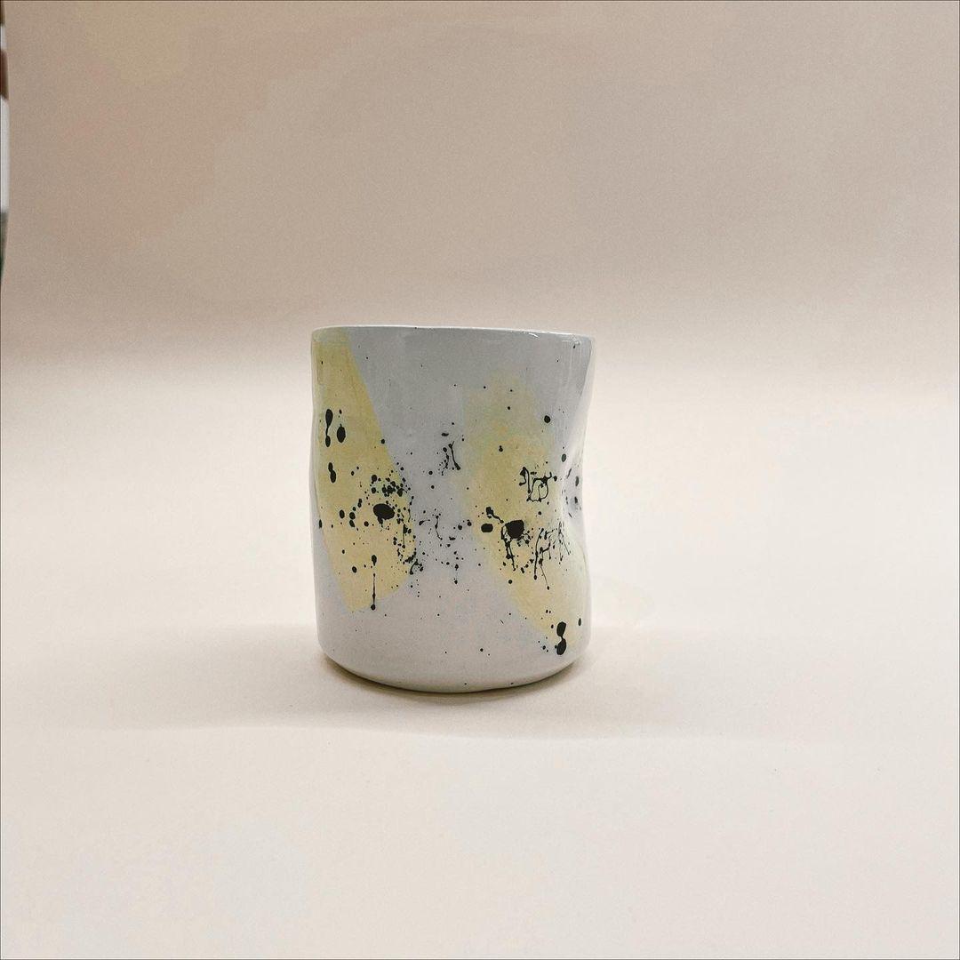 white vase with yellow and black brushes